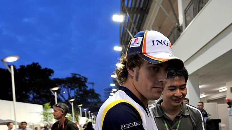 El piloto español de Fórmula Uno Fernando Alonso del equipo Renault camina por el paddock del circuito de Marina Street en Singapur hoy jueves 25 septiembre. El Gran Premio de Fórmula Uno de Singapur tendrá lugar por primera vez en este país el próximo domingo 28 de septiembre y también será el pionero en celebrarse por la noche.