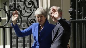 Theresa May junto a su marido Philip May saludan tras abandonar Downing Street.