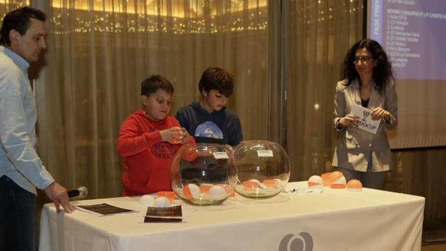 Chus Hevia, organizador, y Carmen Mier, responsable de comunicación, durante el sorteo, con dos participantes.