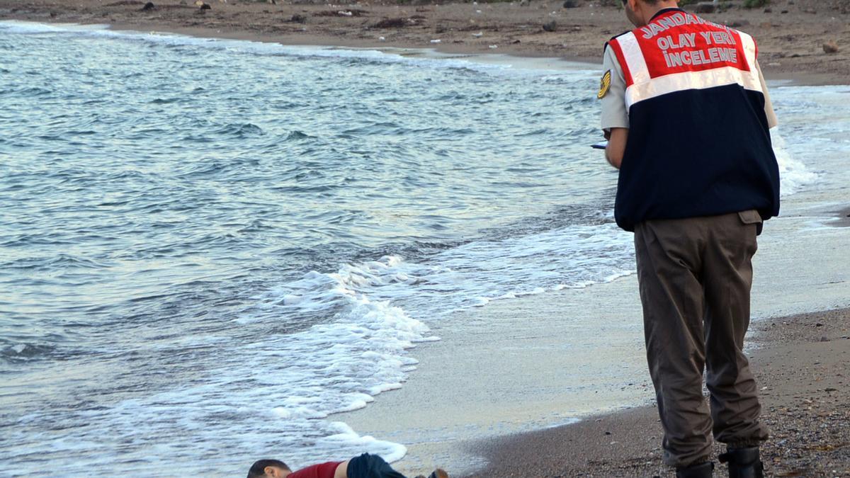 Un oficial, ante el cuerpo de Aylan Kurdi en una imagen ya icónica de los fenómenos migrantes.
