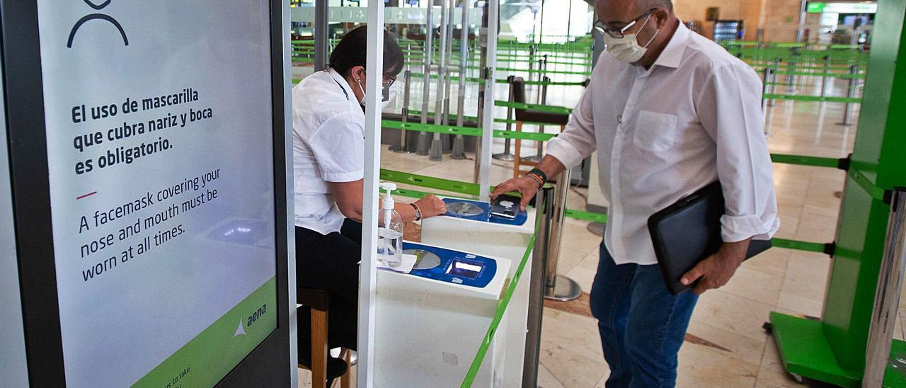 Un hombre escanea el código QR de su tarjeta digital de viaje en un control del aeropuerto de Tenerife Norte. | | CARSTEN W. LAURITSEN