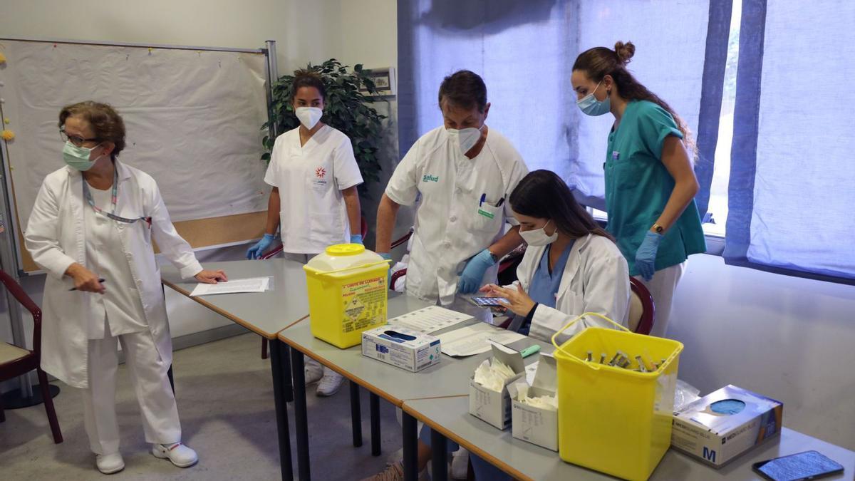 Varios sanitarios de un centro de salud preparan las vacunas antigripales para usuarios de la residencia San Eugenio, en Zaragoza.