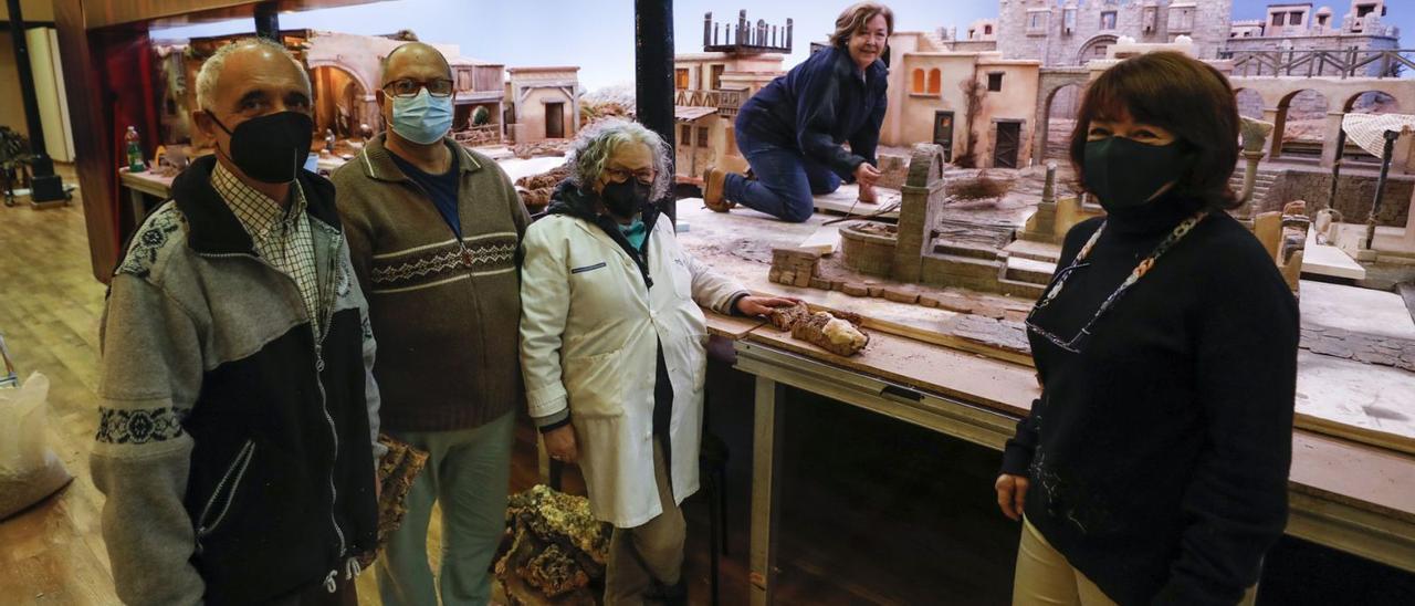 Por la izquierda, Celestino Cuervo, Ramón Villa, Pilar Fernández, Eulalia Nacimiento y Ana Gómez, ayer, en Trascorrales montando la tradicional exposición navideña de la Asociación Belenista de Oviedo. | Luisma Murias