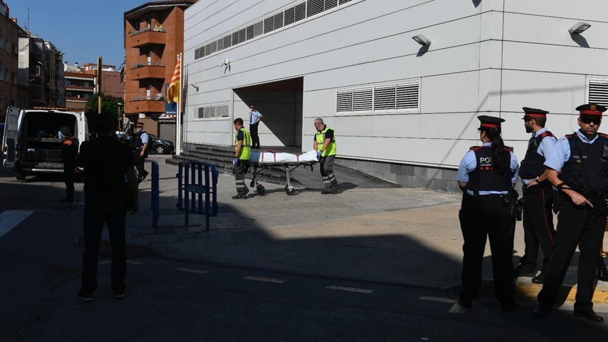 Miembros de la funeraria judicial retiran el cadaver de la comisaria de los mossos en Cornella