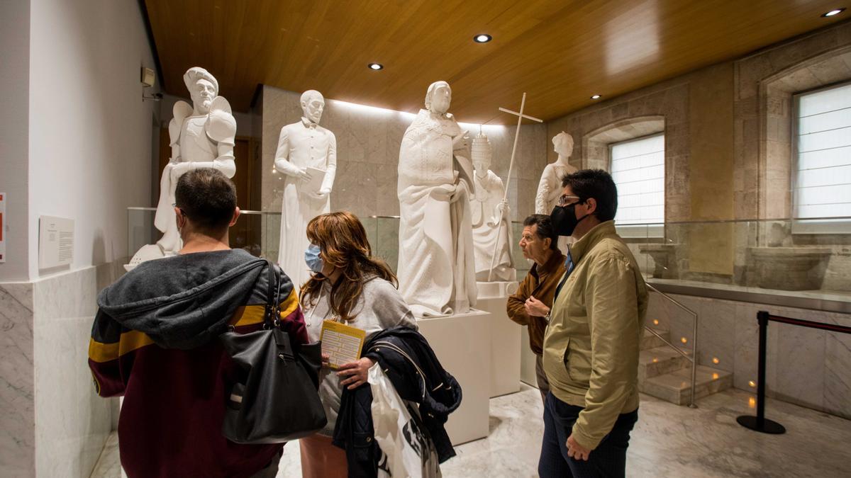 Un grupo de valencianos pasa ante las estatuas de los Borja de Manolo Boix