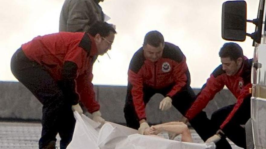 Efectivos de la Ertzaintza cubren el cadáver de una mujer, cuya identidad se desconoce, tras ser rescatada hoy en la desembocadura del río Urumea, junto al Kursaal de San Sebastián.