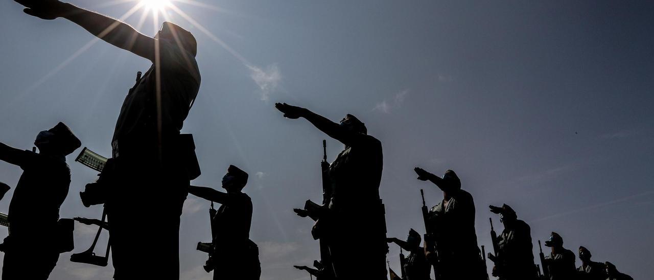 Los soldados españoles montan guardia con sus armas durante un desfile.