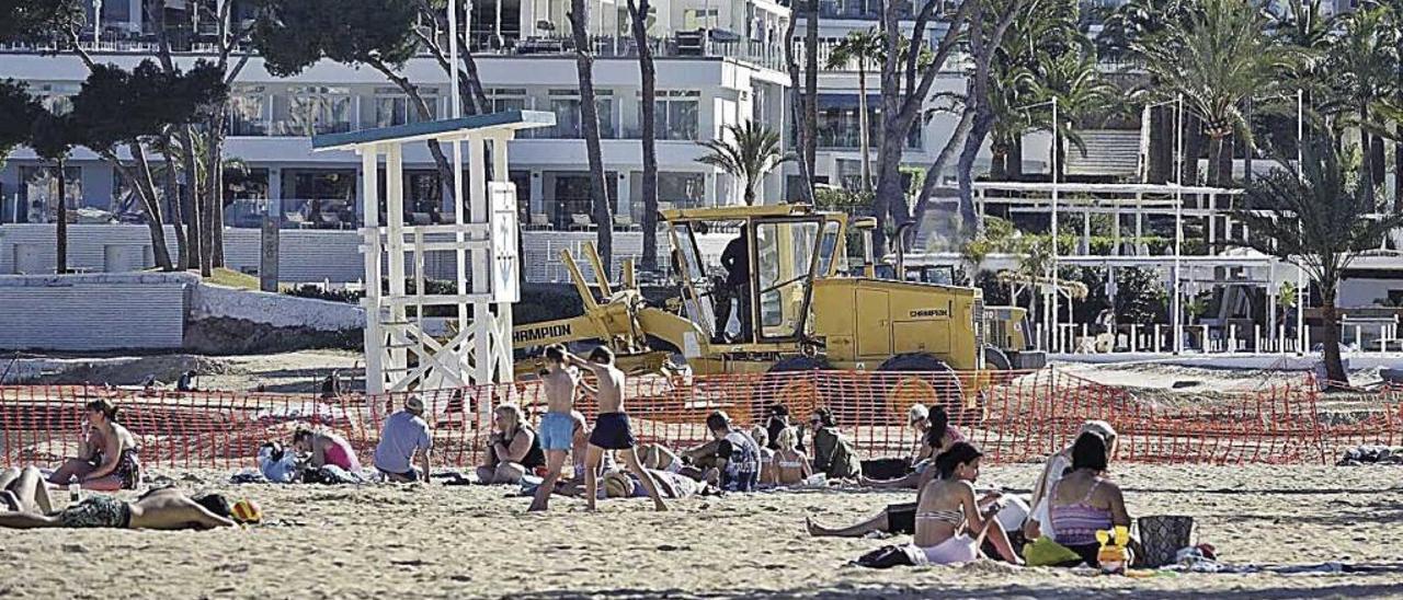 Turistas disfrutan del sol en una playa &#039;calvianera&#039; cercada por obras.