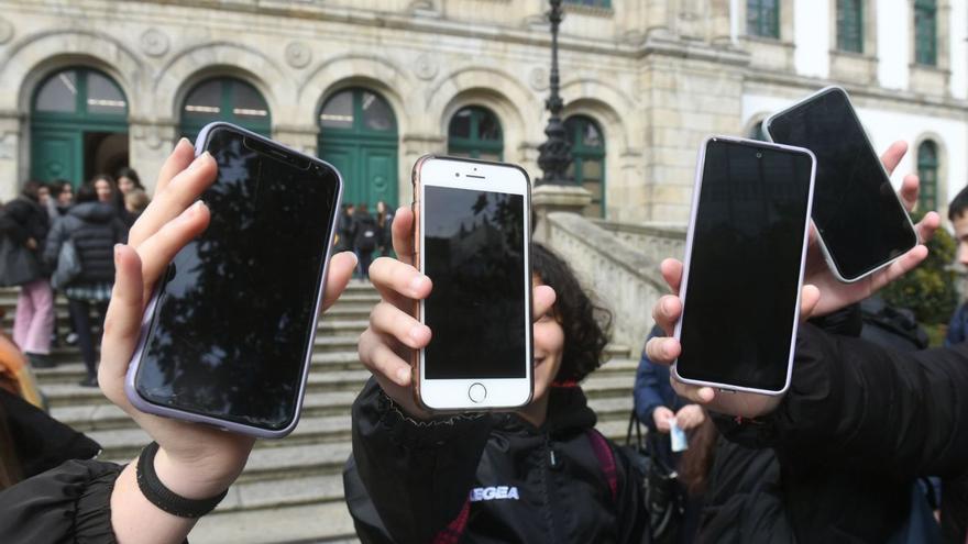 Alumnas con sus teléfonos móviles al salir de clase ayer en el instituto Eusebio da Guarda. |   // CARLOS PARDELLAS