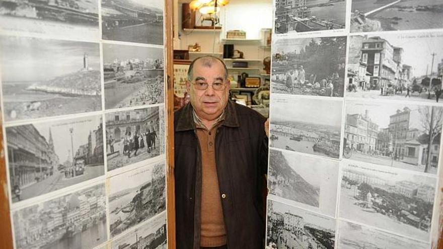 Alberto Murias posa entre las puertas de su local, decoradas con fotografías antiguas. / víctor echave