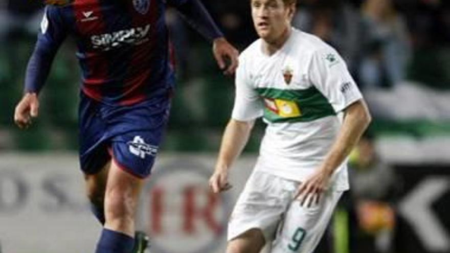 Álex Fernández lucha por un balón en el Elche-Huesca.