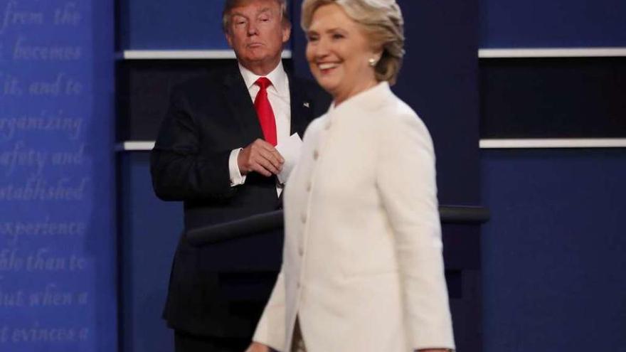 Hillary Clinton y, al fondo, Donald Trump.