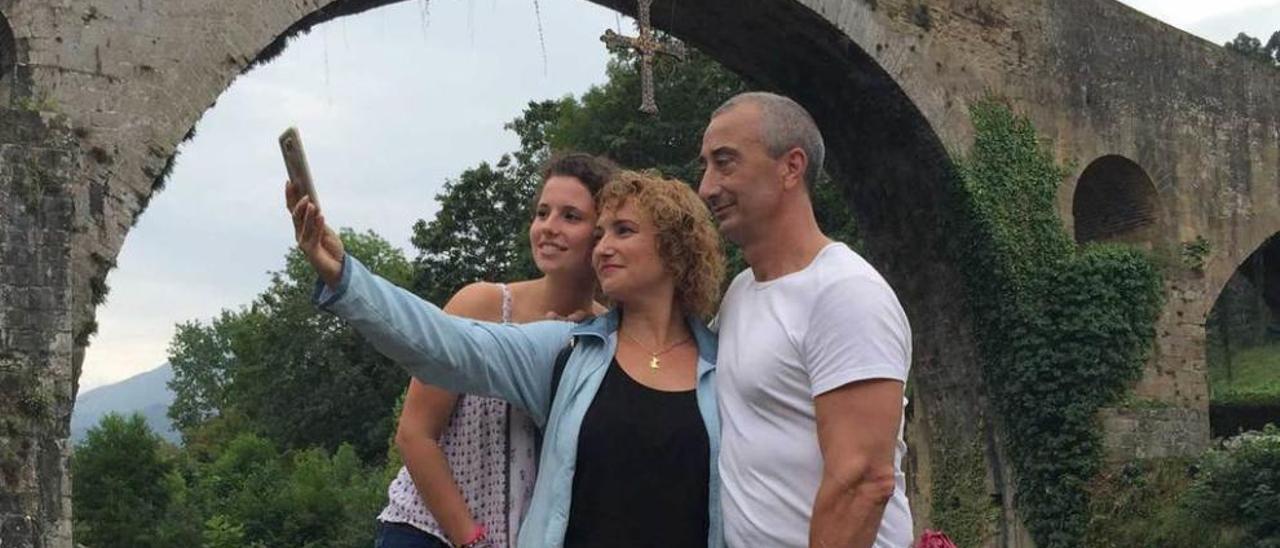 En la imagen superior, Manolo Cazorla, Emilia Belmonte, Ismael Monteserín y José Monteserín junto a la oficina de turismo. Sobre estas líneas, Mireia Aparicio, Ita Gil y Miguel Rubio se hacen un selfie ante el puente &quot;romano&quot;, ayer.