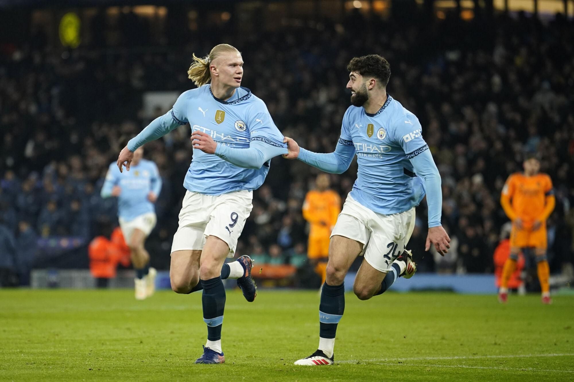 Manchester City's Erling Haaland, left, celebrates with Manchester City's Josko Gvardiol after scoring his sides first goal during the Champions League playoff first leg soccer match between Manchester City and Real Madrid at the Etihad Stadium in Manchester, England, Tuesday, Feb. 11, 2025. (AP Photo/Dave Thompson)