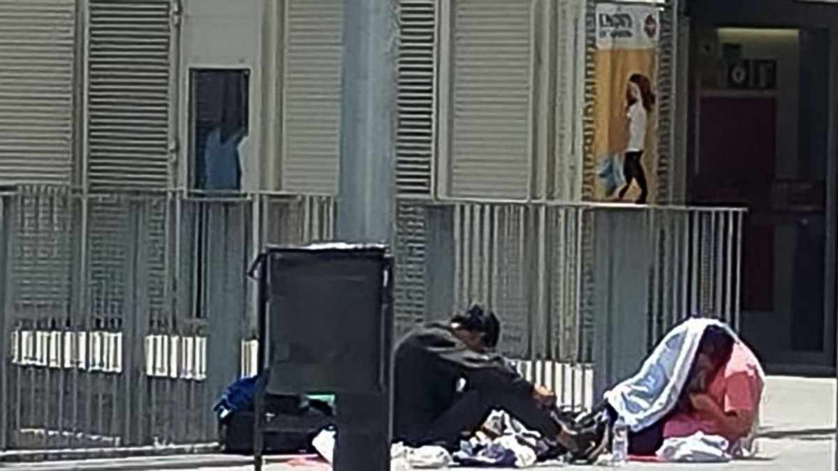 Dues persones consumeixen drogues en una de les entrades del mercat de Sant Antoni.  | EL PERIÓDICO