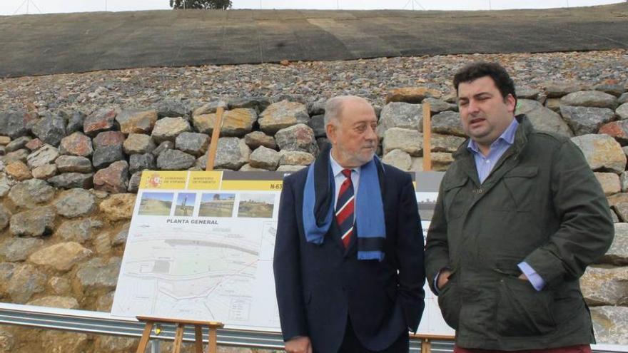 El delegado del Gobierno, Gabino de Lorenzo, y el alcalde de Salas, Sergio Hidalgo, en la reapertura de la carretera, con las obras de contención del argayo al fondo.