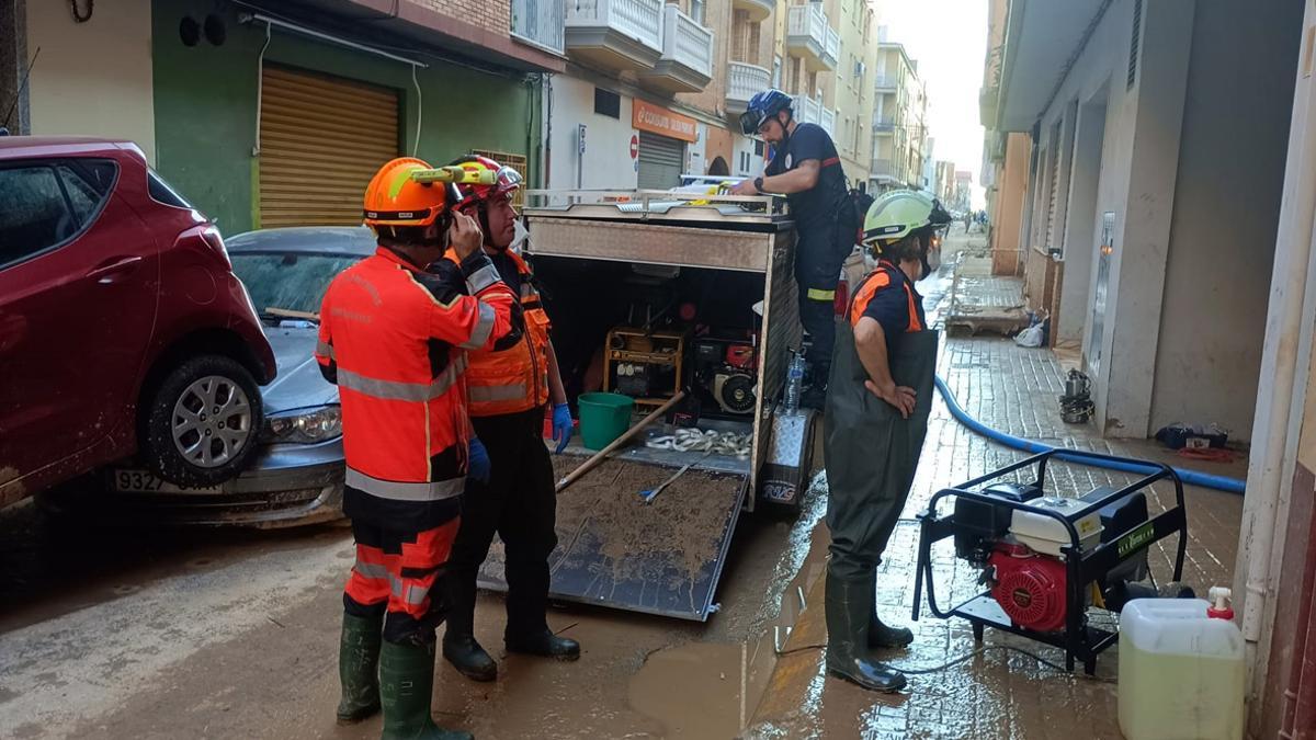 Efectivos de Protección Civil de Valga limpiando un garaje afectado por la dana en Valencia.