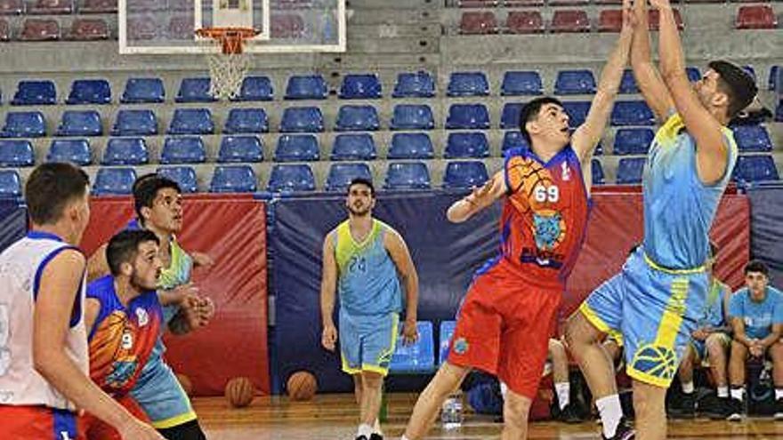 El jugador visitante José Ignacio lanza a canasta ante la oposición de Adrián Sánchez.