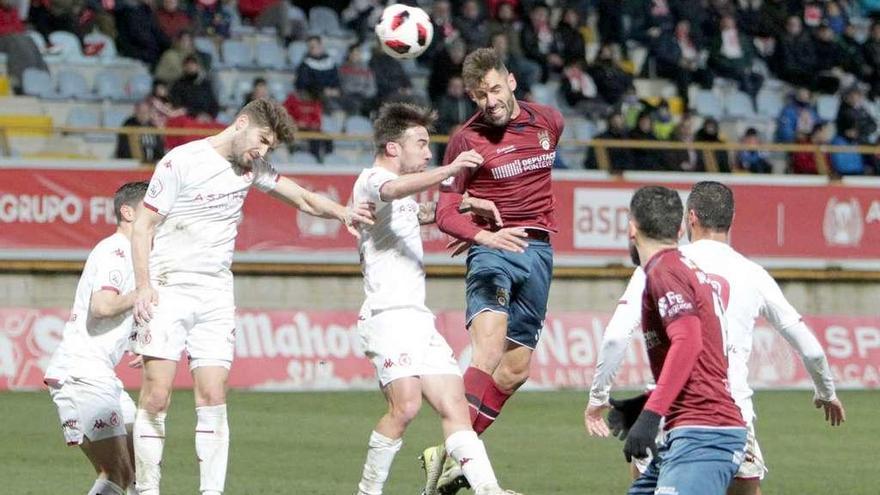 Adrián León remata de cabeza rodeado de jugadores de la Culural Leonesa. // Área 11