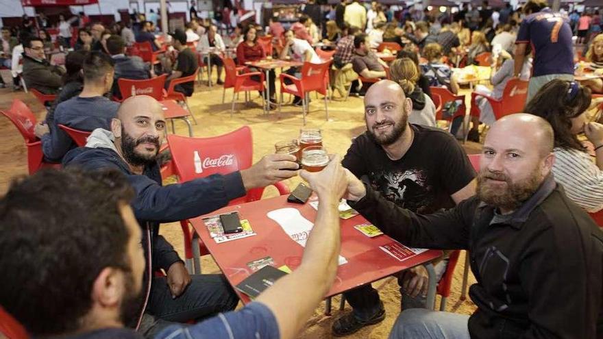 Un grupo de amigos brinda con cerveza en el festival de El Bibio.