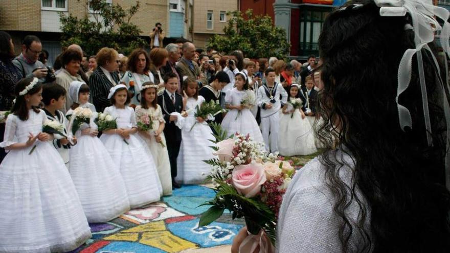 A la izquierda, los niños, en corro, en la plaza de La Baragaña. A la derecha, la custodia, a su paso por la calle Valdés Pumarino de Candás.