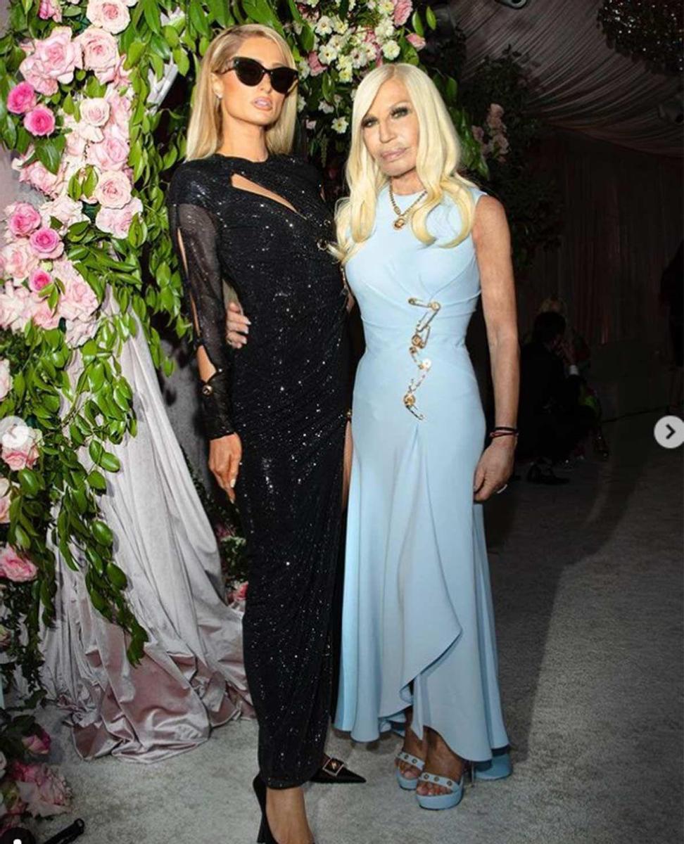 Paris Hilton, de negro, y Donatella Versace, de azul y con imperdibles marca de la casa