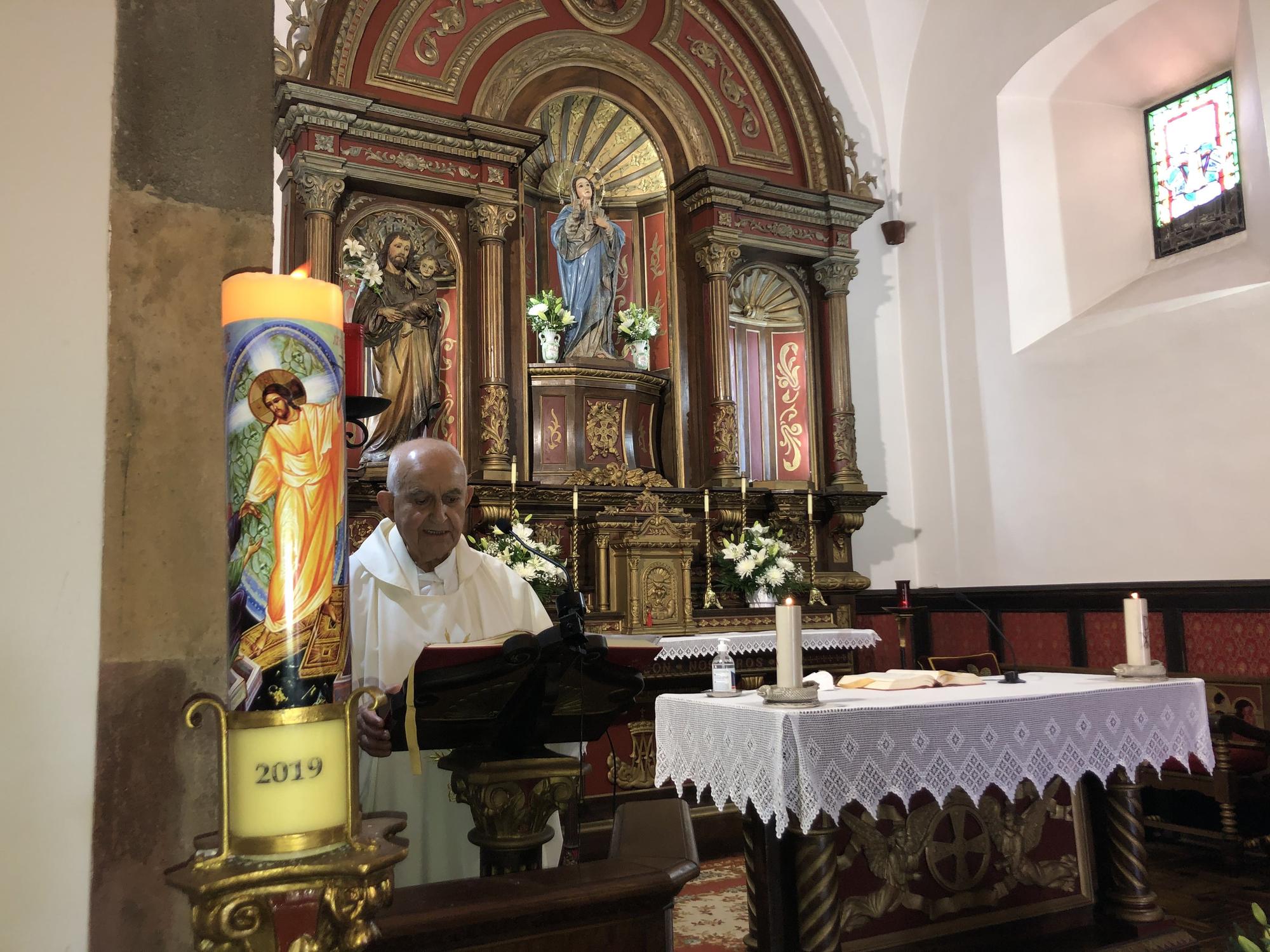 El párroco local, durante la misa, con la vela con la fecha &quot;2019&quot; como modo de homenaje