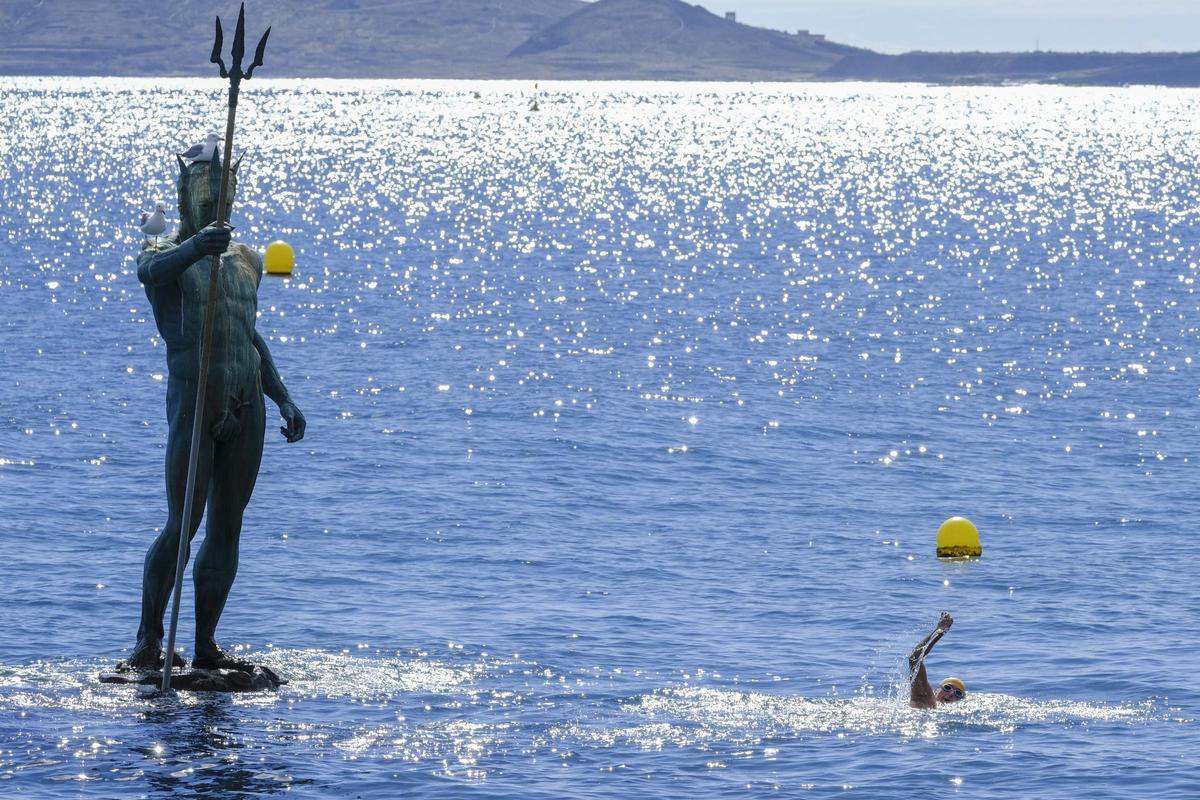Un bañista nada en la playa de Melenera.
