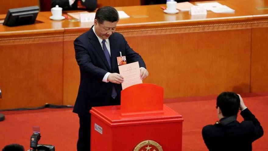 El presidente chino, Xi Jinping, deposita su voto en la sesión de ayer de la Asamblea Nacional Popular. // AFP