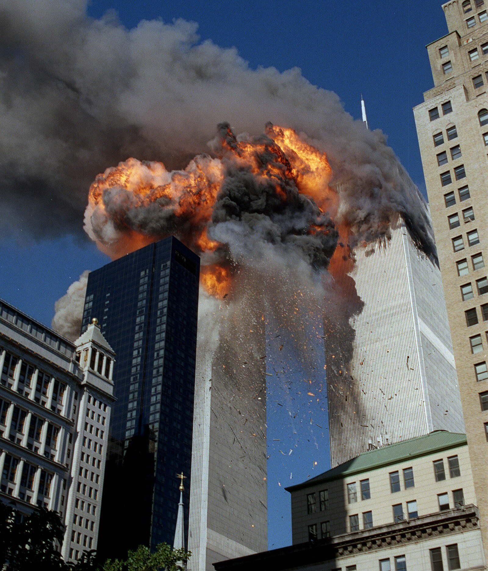Una enorme bola de fuego, humo y escombros salen despedidos de la segunda torre tras el impacto del avión contra el edificio.