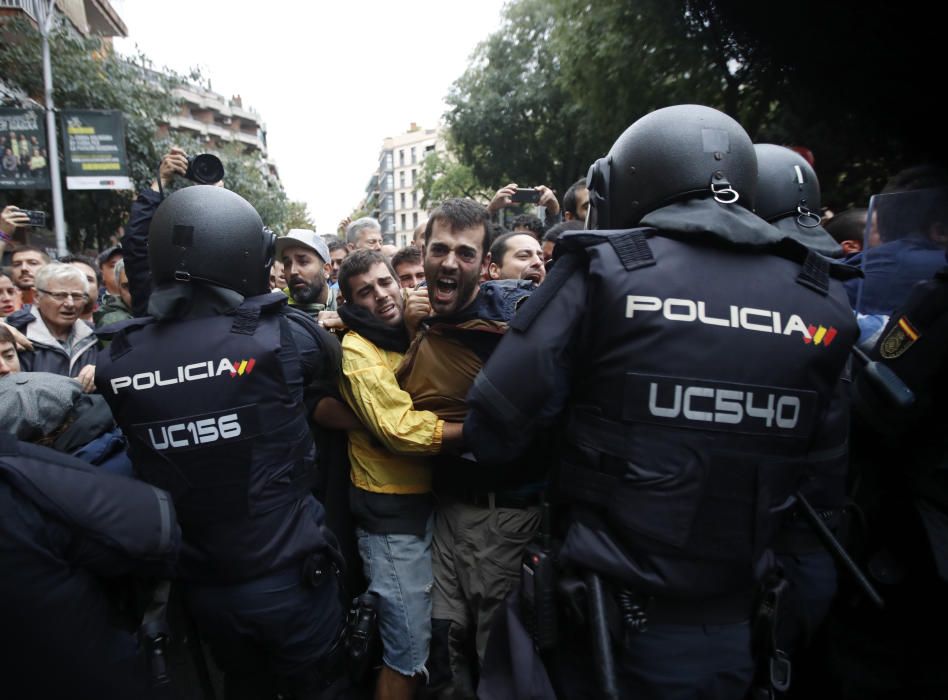 Varios manifestantes intentan abrirse paso entre los agentes policiales.