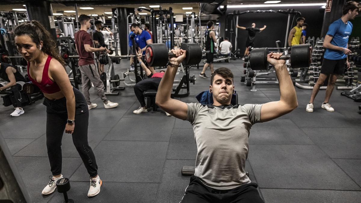 Varias personas se ejercitan en un gimnasio.