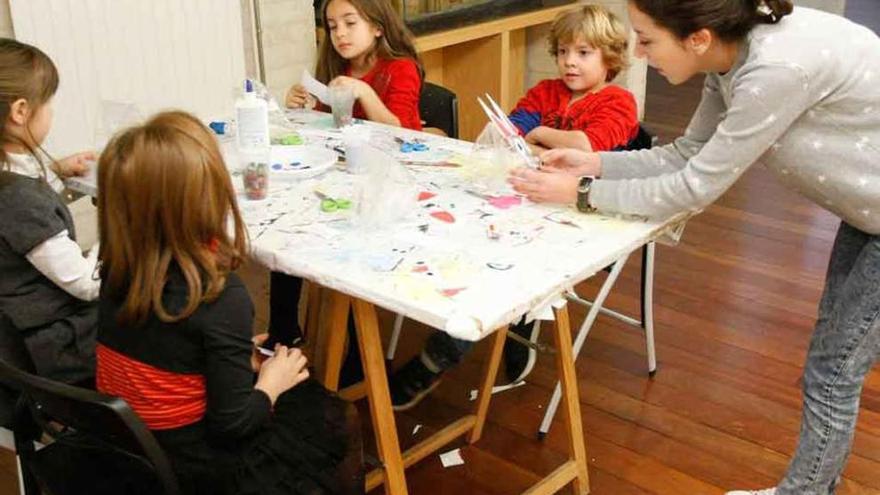 Los niños trabajan con la educadora con material reciclado.