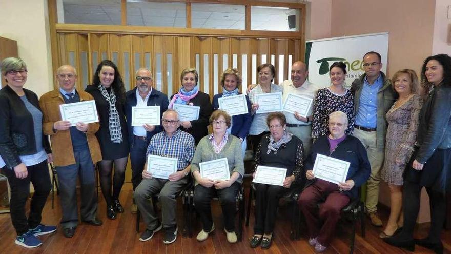 Los participantes muestran sus diplomas junto a los encargados de impartir el curso de promoción de la salud en Tineo.