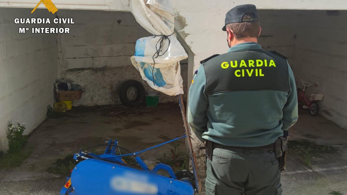 Un agente de la Guardia Civil junto a la máquina recuperada