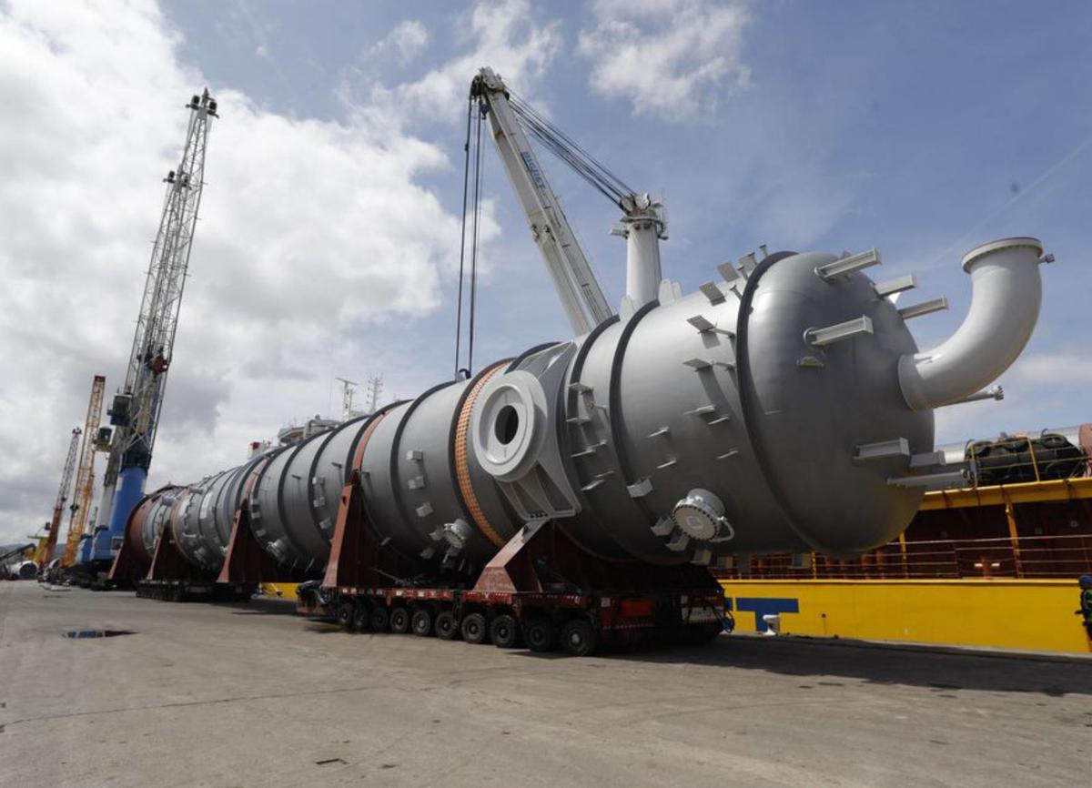 Arriba, la segunda torre de proceso a su llegada al pie del «Happy Star». Sobre estas líneas, los operarios del barco reciben la primera pieza sobre la cubierta. Abajo, las dos torres, desde los muelles. | Ricardo Solís /  BigLift