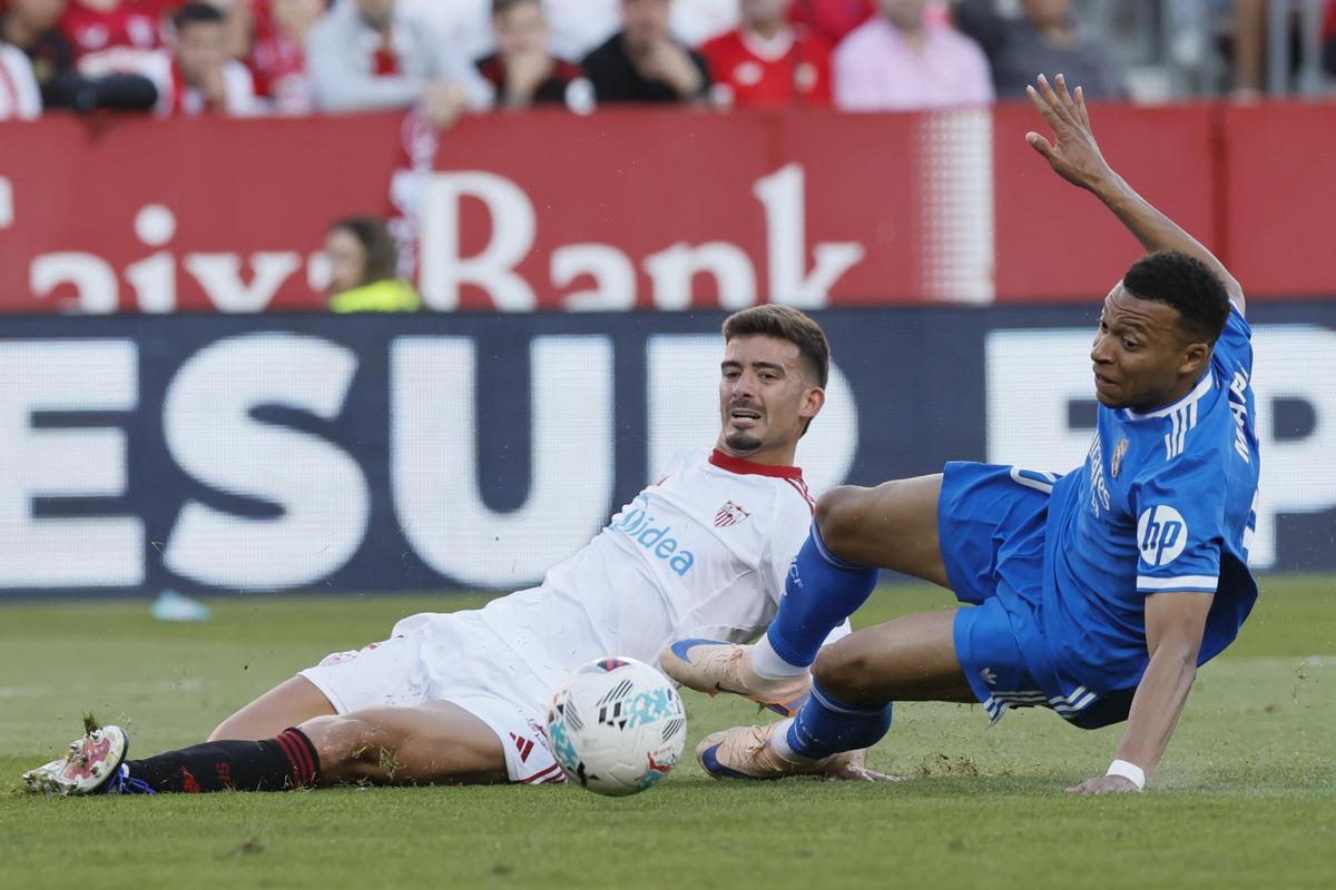 El delantero del Real Madrid Kylian Mbappé (d) disputa un balón con el defensa del Sevilla Kike Salas (i) durante el partido de la jornada 37 de LaLiga que Sevilla FC y Real Madrid disputan hoy domingo en el estadio Ramón Sánchez-Pizjuán, en Sevilla.