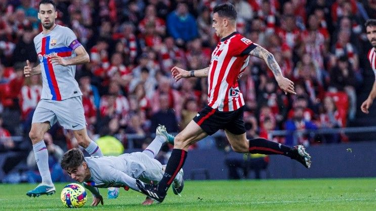 Gavi intenta despejar con la cabeza ante Dani García, el centrocampista del Athletic, en San Mamés.