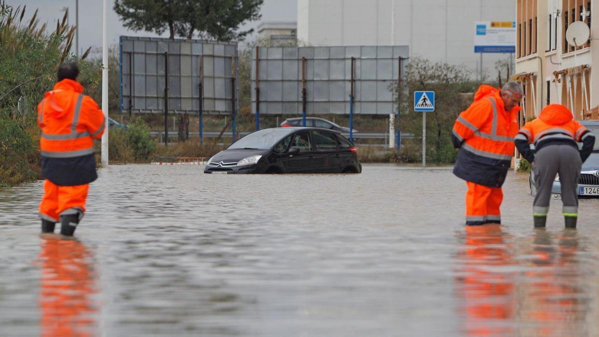 Un vehículo atrapado en la calle Mar Menor del plan parcial El Paraíso tras las lluvias. | TONY SEVILLA