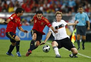 Els jugadors espanyols Santi Cazorla, a l’esquerra, i Xavi Hernández, al centre, disputen la pilota amb l’alemany Marcell Jansen durant la final de l’Eurocopa 2008 a l’Estadi Ernst Happel de Viena (Àustria).