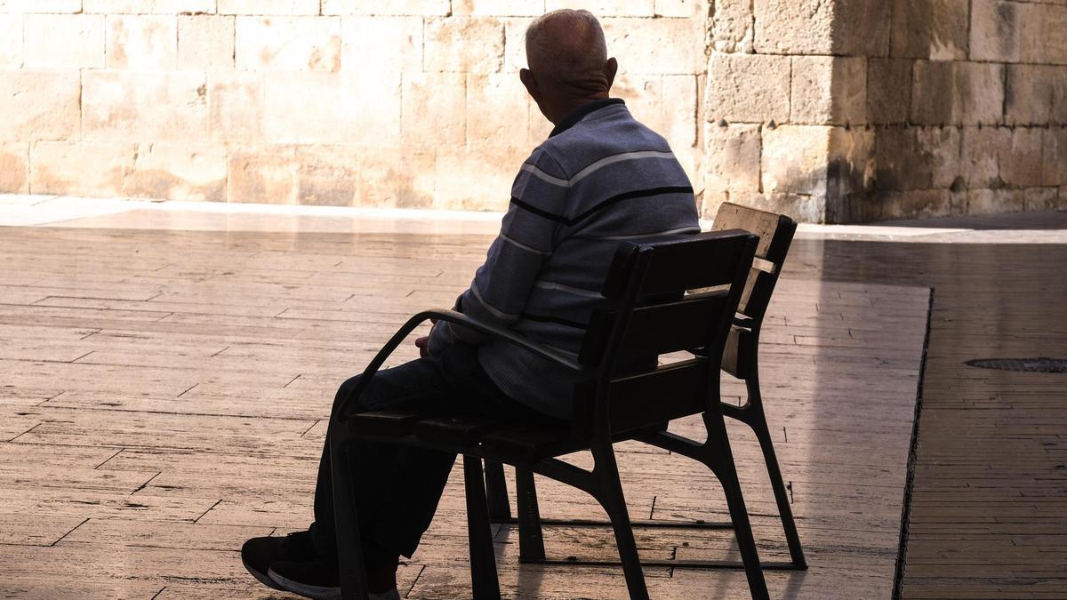 Un anciano sentado en un banco de la calle Obispo Tormo, en Elche