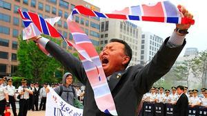 Un manifestant de Corea del Sud trenca una bandera nord-coreana en protesta per l’enfonsament d’un vaixell de guerra del seu país a prop de la frontera entre les dues nacions.