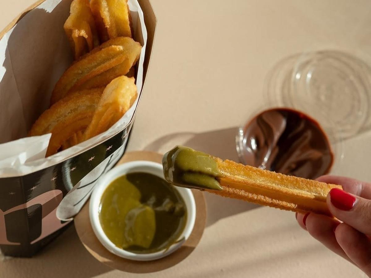 Churros bañados en salsa de pistacho.