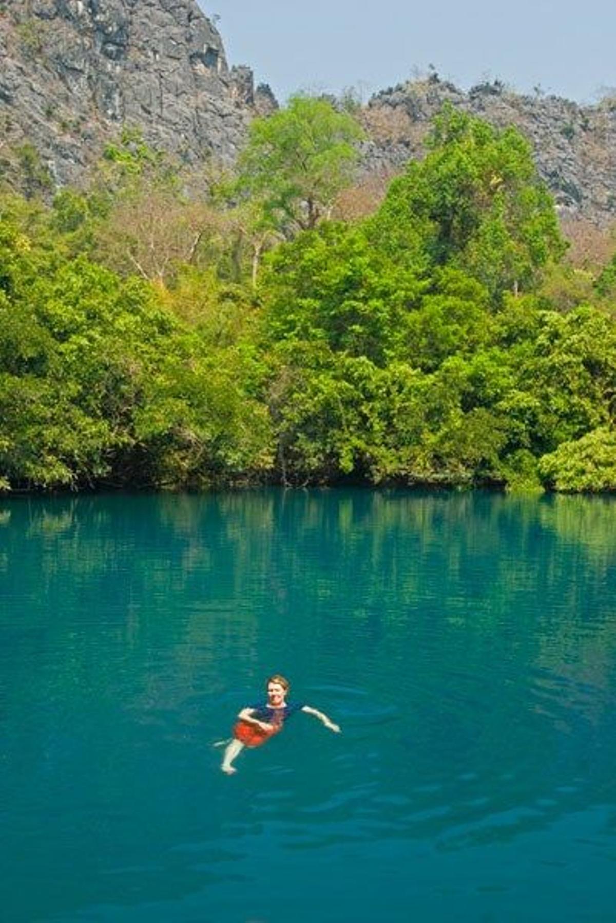 Mujer nadadndo en el agua clara de la laguna de Khoun Khong Lang cerca de la ciudad de Na Kue, en Laos.