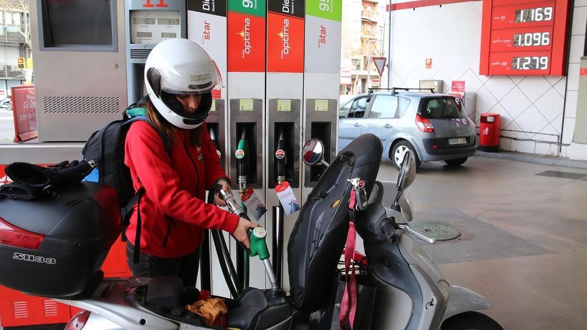 Una chica pone en gasolina en una estación de Barcelona, el 22 de marzo del 2016