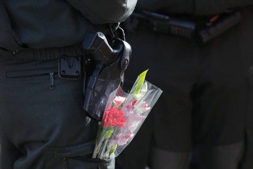 Un oficial de policía con flores en el bolsillo