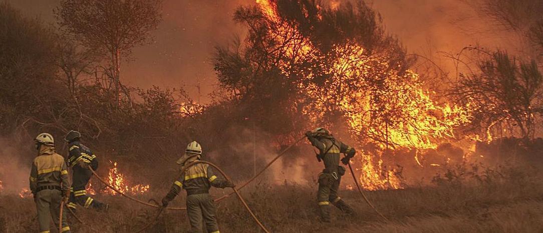Una brigada hace frente a una llamarada de fuego, en un incendio en Cualedro en 2020. // BRAIS LORENZO