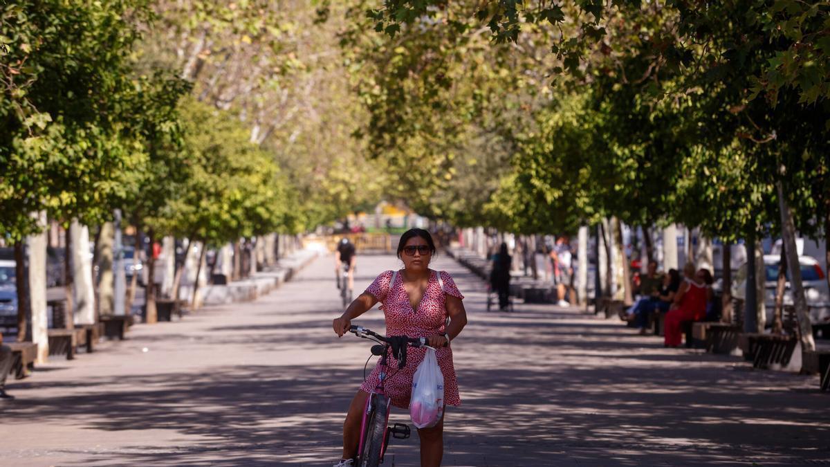 Una mujer circula en bicicleta por la avenida Gran Vía Parque.
