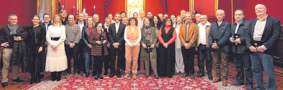 En el centro, de naranja, la alcaldesa, Goretti Sanmartín acompañada por los miembros de la corporación municipal y el personal homenajeado en el acto