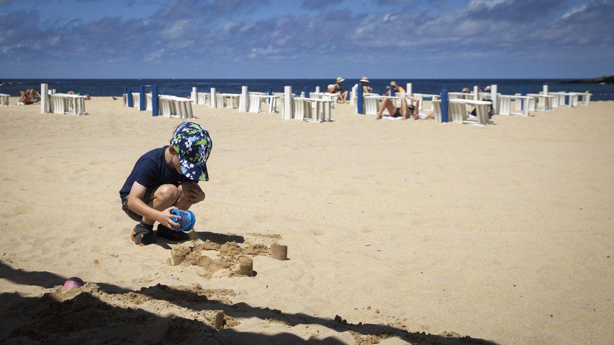 Un niño juega en la playa.